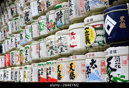 Fûts de saké colorés à l'entrée de la route de gravier du sanctuaire Meiji Jingu à Tokyo, Japon. Banque D'Images