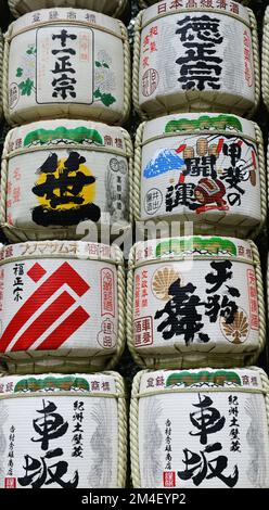 Fûts de saké colorés à l'entrée de la route de gravier du sanctuaire Meiji Jingu à Tokyo, Japon. Banque D'Images