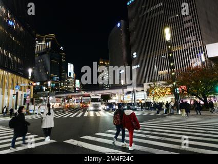 Piétons traversant la route à Ginza avec le quartier des affaires Yurakucho en face d'eux. Tokyo, Japon. Banque D'Images