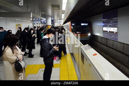 Passagers japonais attendant de monter à bord du métro à Tokyo, Japon. Banque D'Images