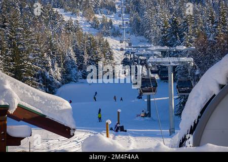 Vue panoramique sur les montagnes enneigées - les surfeurs et les skieurs se trouvent sur les pistes et les remontées mécaniques. Station de ski à Whistler, Canada Banque D'Images