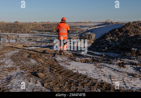 Fehmarn, Allemagne. 16th décembre 2022. Un travailleur se rend à la fosse d'excavation pour le portail du tunnel de Fehmarnbelt. Le tunnel routier et ferroviaire de 18 kilomètres relie l'île de Fehmarn à l'île danoise de Loland à partir de 2029. Selon Femern A/S, le coût est de 7,1 milliards d'euros. Credit: Christian Charisius/dpa/Alay Live News Banque D'Images