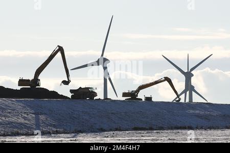 Fehmarn, Allemagne. 16th décembre 2022. Les excavatrices travaillent sur une zone de stockage au sol pour l'excavation de la tranchée du tunnel sur le site de construction du tunnel de la mer Baltique près de Puttgarden. Le tunnel routier et ferroviaire de 18 kilomètres relie l'île de Fehmarn à l'île danoise de Loland à partir de 2029. Selon Femern A/S, le coût est de 7,1 milliards d'euros. Credit: Christian Charisius/dpa/Alay Live News Banque D'Images