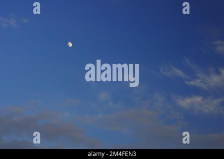 Photo réelle du ciel au crépuscule, des nuages lumineux et de la lune. Mise au point autour du cadre. Banque D'Images