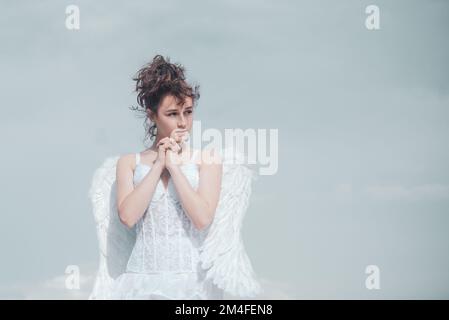 Saint Valentin ange adolescence priing. Ange adolescent, fille avec des ailes sur fond de ciel. Concept de la Saint-Valentin. Ange adolescent dans le ciel. Banque D'Images