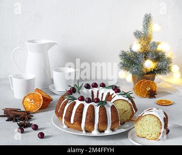 Gâteau de Noël, pudding sur une assiette blanche avec des oranges séchées et des tasses pour le café en arrière-plan. Copier l'espace. Banque D'Images