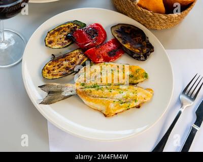 Légumes cuits au four et filet de bream sur l'assiette, dorada a la plancha, plat traditionnel espagnol Banque D'Images