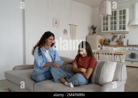 Mère souriante positive faisant la paix avec offensé, agacé adolescent après le combat Banque D'Images