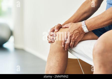 En attente de voir le médecin. un homme méconnaissable assis sur un lit pendant sa physiothérapie. Banque D'Images