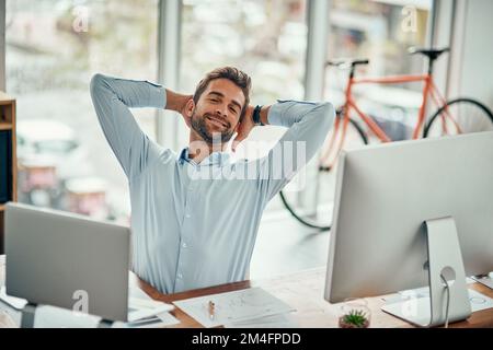 Je pense que je mérite une pause après tout ce travail acharné. Portrait d'un beau jeune homme d'affaires prenant une pause à son bureau. Banque D'Images