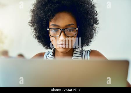 Travailler dur à ces conceptions. une jeune femme designer travaillant dans un bureau moderne. Banque D'Images