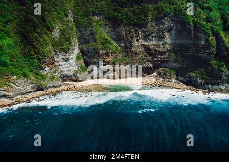 Littoral océanique avec plage, falaise rocheuse et océan avec vagues à Bali. Vue aérienne. Banque D'Images