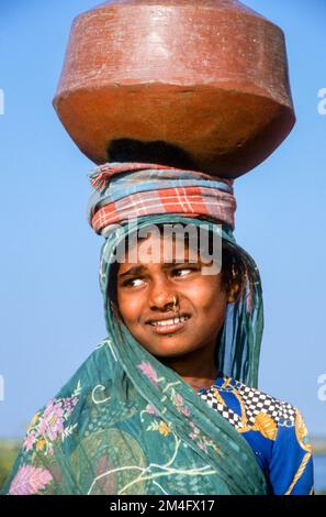 Jeune fille portant de l'eau du puits pour sa maison Banque D'Images