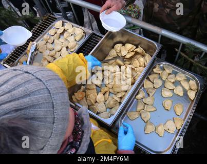 Cracovie. Cracovie. Pologne. Mains donnant et prenant les boulettes pendant la veille de Noël pour les pauvres et les sans-abri à la place du marché principal. Banque D'Images