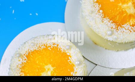 Petits gâteaux à l'orange et à la noix de coco sur fond bleu Banque D'Images