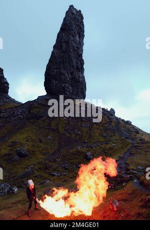 Île de Skye, Écosse, Royaume-Uni. 24th octobre 2021. Une personne avec un masque Boris Johnson et une autre avec un réservoir d'huile pour une tête, représentant les compagnies pétrolières, utilisent un lanceur de flamme pour brûler un arbre qui représente le dernier arbre sur terre. Cette manifestation théâtrale a été organisée par Ocean Rebellion, un mouvement frère de la rébellion d'extinction, dans le vieil homme de Storr, île de Skye en Écosse, avant le début de la CdP 26 à Glasgow. Banque D'Images