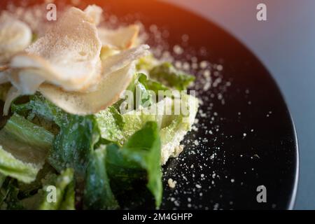 salade césar claire sans viande sur plaque noire sur fond sombre Banque D'Images