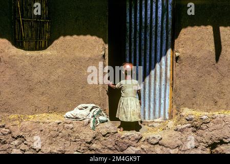 Éthiopie, 1970s, village juif de Falésha, vue arrière de la petite fille entrant dans la porte, Beta Israël Farachas Juifs Éthiopiens juif, région d'Amhara, Afrique de l'est, Banque D'Images