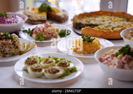 Repas maison sur une table festive du nouvel an avec accent sur la salade mimosa. Banque D'Images