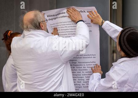 Düsseldorf, Allemagne. 21st décembre 2022. Les activistes du groupe 'rébellion citiste' coller des affiches sur la façade et sur les fenêtres. Les militants écologistes ont protesté devant l'entrée du Ministère de l'économie, de l'industrie, de la protection du climat et de l'énergie de l'État de Rhénanie-du-Nord-Westphalie pour la préservation du village de Lützerath à la mine à ciel ouvert Garzweiler. Credit: Christoph Reichwein/dpa/Alay Live News Banque D'Images