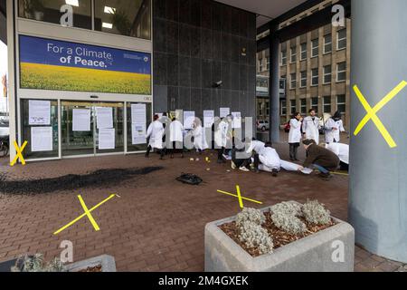 Düsseldorf, Allemagne. 21st décembre 2022. Les activistes du groupe 'rébellion citiste' coller des affiches sur la façade et sur les fenêtres. Les militants écologistes ont protesté devant l'entrée du Ministère de l'économie, de l'industrie, de la protection du climat et de l'énergie de l'État de Rhénanie-du-Nord-Westphalie pour la préservation du village de Lützerath à la mine à ciel ouvert Garzweiler. Credit: Christoph Reichwein/dpa/Alay Live News Banque D'Images