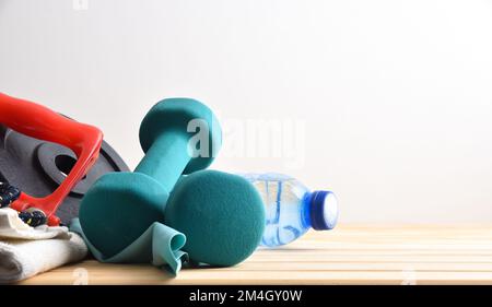 Arrière-plan sportif avec planche en bois avec serviette et bouteille d'eau et fond blanc isolé. Vue avant. Banque D'Images