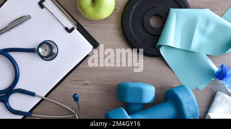Table de technicien médical sportif avec bloc-notes et stéthoscope avec équipement sportif. Vue de dessus. Banque D'Images