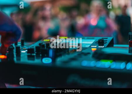 DJ joue de la musique disco avec son console dans un pub Banque D'Images