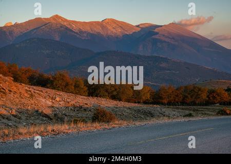 Une route pavée et vide dans le massif du Mont Olympe en Grèce au coucher du soleil Banque D'Images