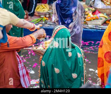 Le dévot priant avec des offrandes religieuses pour le dieu du soleil dans le festival Chhath Banque D'Images