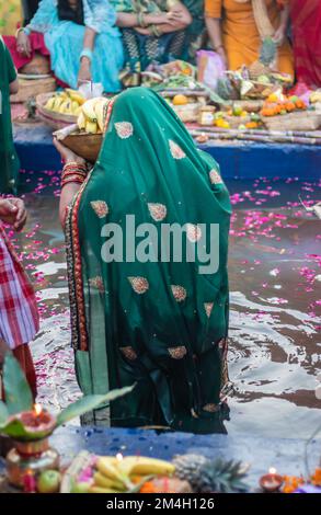 Le dévot priant avec des offrandes religieuses pour le dieu du soleil dans le festival Chhath Banque D'Images