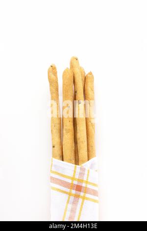 Gressins italiens frais Grissini blancs avec fond de serviette en tissu de cuisine. Pain cuit à sec avec des morceaux d'olive. Vue de dessus, espace de copie Banque D'Images