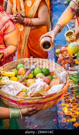 Le dévot priant avec des offrandes religieuses pour le dieu du soleil dans le festival Chhath Banque D'Images