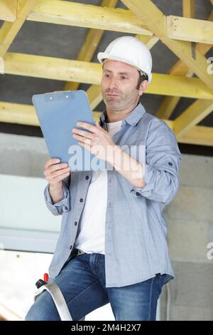 contremaître mature regardant le presse-papiers Banque D'Images