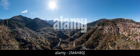 Metsovo Anilio, Epirus Grèce. Vue aérienne panoramique de drone du village traditionnel sur la montagne de Pindus, pont de la route nationale Egnatia, ciel bleu dos Banque D'Images
