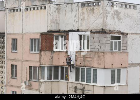 Tiraspol, Moldavie - 10 décembre 2022 : un constructeur de haute altitude isole la façade d'un immeuble d'appartements en plastique mousse. Maison isolante aérée Banque D'Images