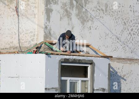 Tiraspol, Moldavie - 13 décembre 2022: Les travailleurs sont en train de construire sur le toit de cadre pour le balcon. Banque D'Images