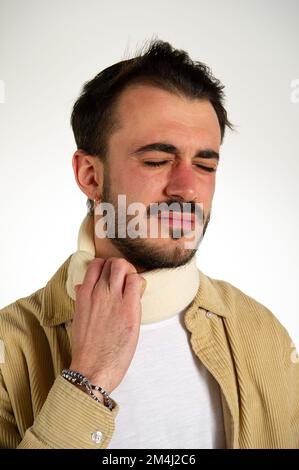 Homme avec un collier orthopédique autour de son cou et montre une grimace de la douleur, whiplash concept après un accident Banque D'Images