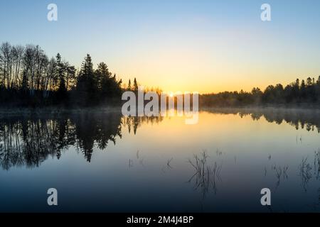 Brumes matinales au lever du soleil sur un étang de castors au début du printemps, Grand Sudbury, Ontario, Canada Banque D'Images