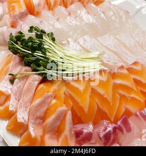 Une assiette de divers poissons crus avec des pousses de saumon, de flétan et de radis en Corée du Sud Banque D'Images