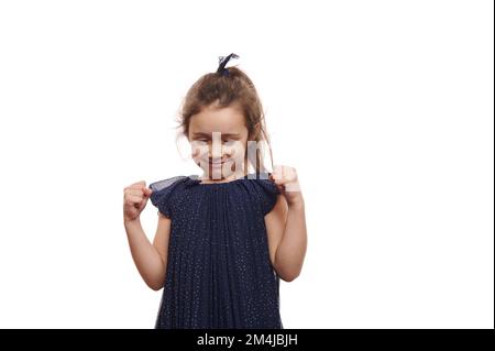 Portrait isolé sur fond blanc d'une adorable petite fille souriante dans une robe élégante, sur fond blanc Banque D'Images