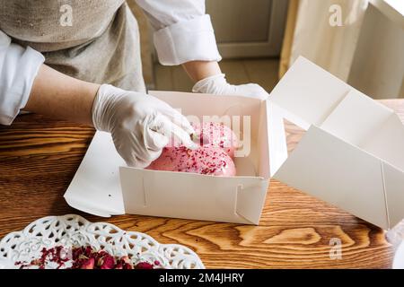 Idées de marketing de la Saint-Valentin pour les petites entreprises. Le chef confiseur fait un coeur rose miroir mousse gâteau Banque D'Images