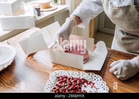 Idées de marketing de la Saint-Valentin pour les petites entreprises. Le chef confiseur fait un coeur rose miroir mousse gâteau Banque D'Images