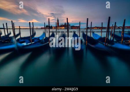 Une longue exposition de gondoles au lever du soleil à Venise, en Italie. Banque D'Images