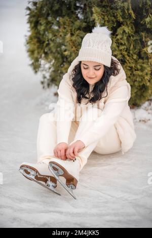 Belle fille s'amuser et mettre sur des patins à glace sur fond d'arbre de noël, Prague, République Tchèque Banque D'Images