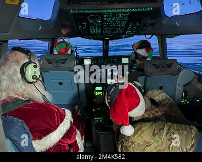 Bethel, États-Unis d'Amérique. 16 novembre 2022. Le Père Noël reçoit un ascenseur à bord d'un avion cargo C-17 Globemaster III de la Garde nationale aérienne de l'Alaska en route pour visiter des communautés éloignées lors de l'opération Père Noël, 16 novembre 2022, dans la baie de Scammon, en Alaska. Le Père Noël et Mme Claus, avec l'aide de la Garde nationale et de l'Armée du Salut, offrent des cadeaux de Noël, des livres, des fournitures scolaires et des friandises aux jeunes des communautés rurales éloignées de l'Alaska. Crédit : SSTGT. Annie Kilborn/Garde nationale/Alamy Live News Banque D'Images