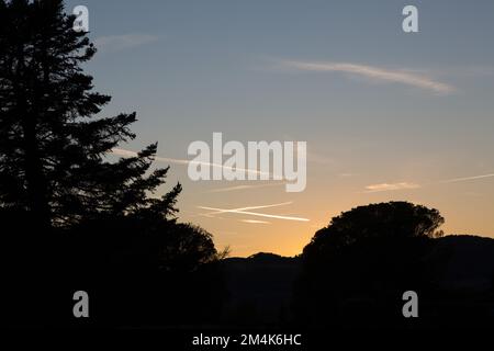 ciel parsemé de pistes d'avion au crépuscule en automne Banque D'Images