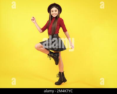 Joyeux portrait d'adolescent. Grande promenade sur isolé de vêtements de studio chapeau, vêtements décontractés, jupe mode et chaussures. Fille souriante. Banque D'Images