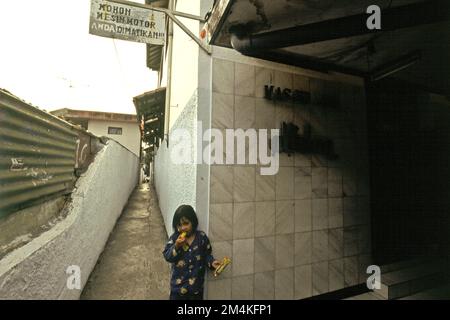 Portrait d'un enfant devant une mosquée située dans un quartier dense près de Gegerkalong, à Bandung, Java-Ouest, Indonésie. Banque D'Images