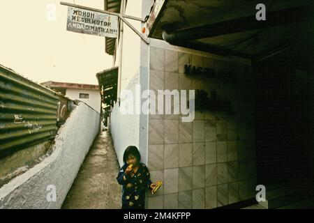 Portrait d'un enfant devant une mosquée située dans un quartier dense près de Gegerkalong, à Bandung, Java-Ouest, Indonésie. Banque D'Images